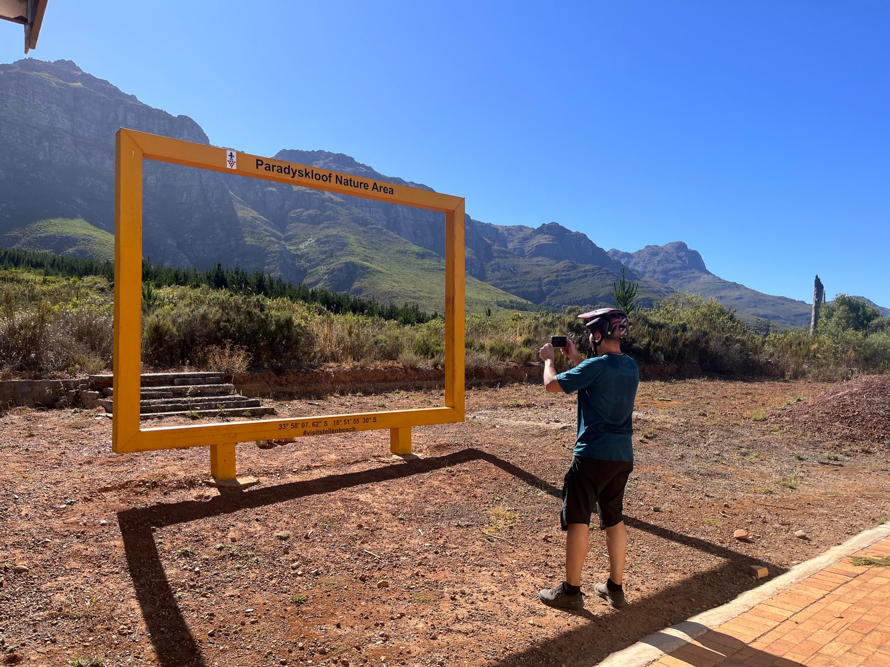 Rider photographing the Botmaskop Nature Area viewpoint frame above Stellenbosch